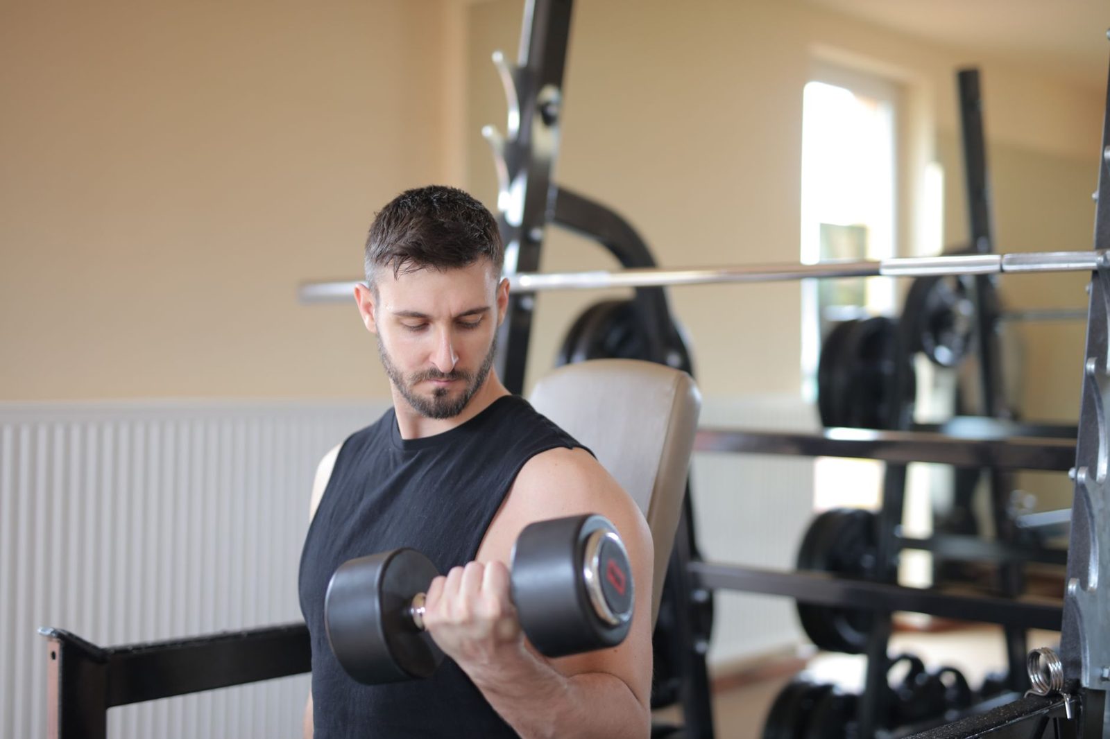 Man curling a dumbbell in his home gym